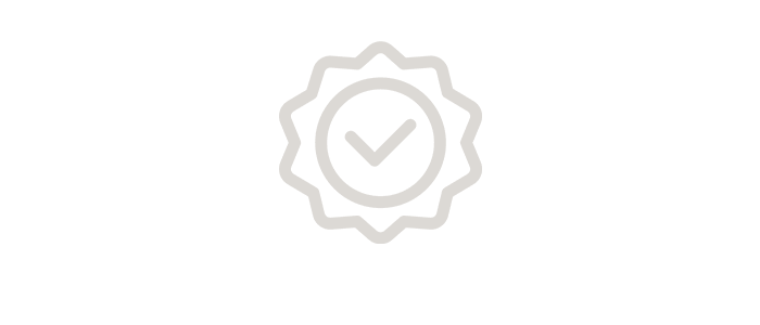 A grey outline of a tick inside a badge or seal, centred on a plain light background.